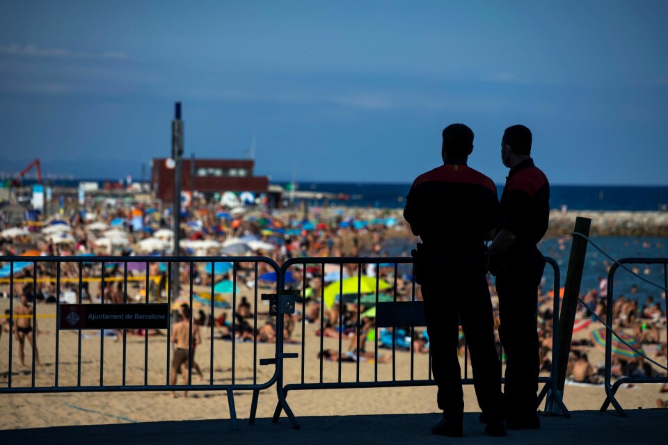 Politiet passer på at ikke flere personer bruker stranden i Barcelona. Mens antallet tilfeller av korona i Nord-Spania øker, er det mange som ikke forholder seg til smittebegrensningstiltakene. Foto: Emilio Morenatti / AP / NTB scanpix