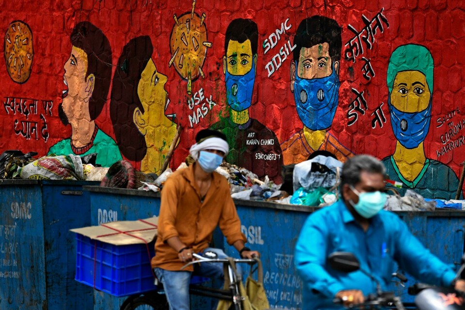 Commuters ride past a mural on COVID-19 coronavirus awareness, painted on a wall along the roadside in New Delhi on July 23, 2020. - India last week became the third country after the United States and Brazil to hit one million cases but many experts say that with testing rates low, the true number could be much higher. (Photo by SAJJAD HUSSAIN / AFP) Commuters ride past a mural on COVID-19 coronavirus awareness, painted on a wall along the roadside in New Delhi on July 23, 2020. - India last week became the third country after the United States and Brazil to hit one million cases but many experts say that with testing rates low, the true number could be much higher. (Photo by SAJJAD HUSSAIN / AFP)