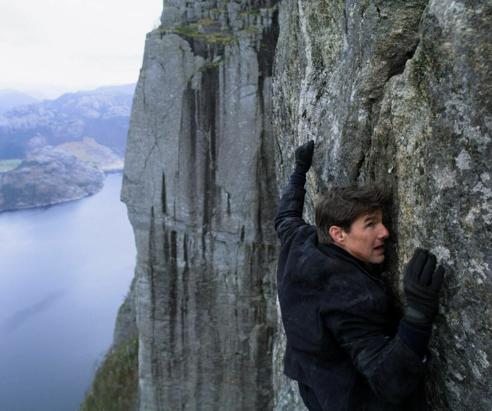 Norske produsenter reagerer på at stor- produksjonen til en åttende «Mission Impossible»-film får unntak fra innreiserestriksjonene og kan spilles inn i Norge. Her henger Tom Cruise i veggen under Preikestolen fra «Mission Impossible: Fallout». Stillbilde: Paramount Pictures