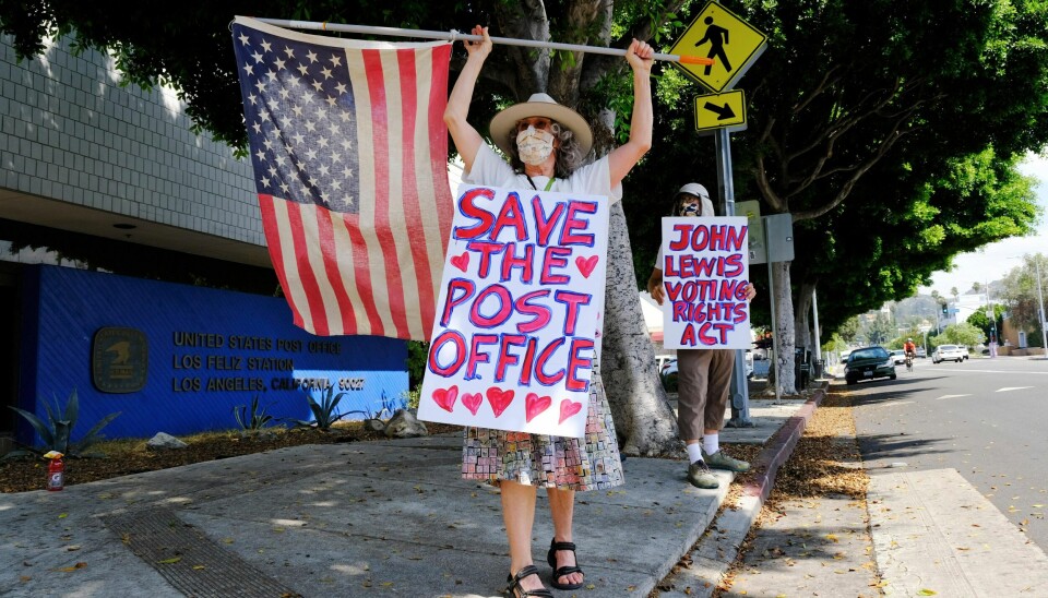 Erica Koesler, left, and David Haerle, both of Los Angeles, demonstrate outside a USPS post office, Saturday, Aug. 15, 2020, in the Los Feliz section of Los Angeles. The USPS has warned states coast to coast that it cannot guarantee all ballots cast by mail for the November election will arrive in time to be counted, even if mailed by state deadlines, raising the possibility that millions of voters could be disenfranchised.(AP Photo/Chris Pizzello)