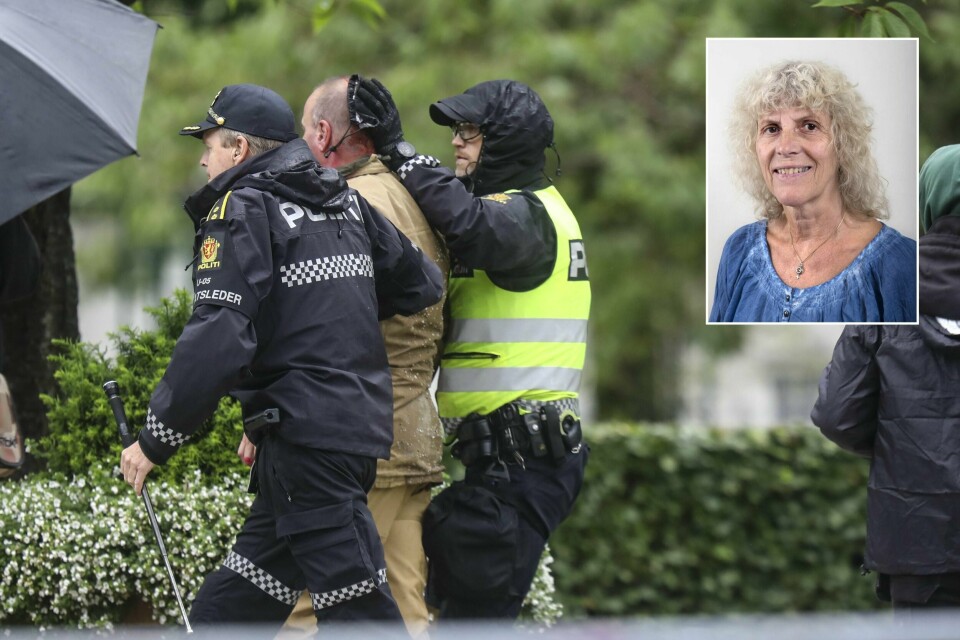 Sian-leder Lars Thorsen geleides bort fra podiet mens det ser ut som han blør fra hodet etter at det brøt ut uroligheter under Sians markering på Festplassen lørdag. Foto: Eivind Senneset / NTB scanpix