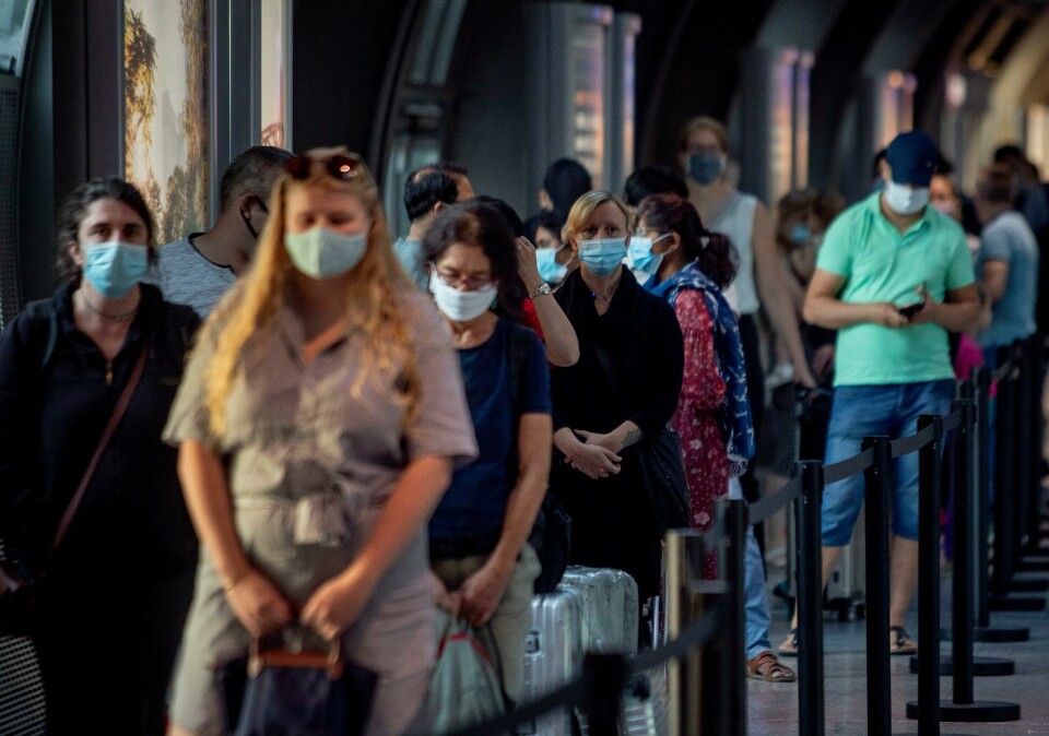 Passasjerer venter på å bli testet for korona på flyplassen i Frankfurt. Passengers queue at a Corona test center at the airport in Frankfurt, Germany, Friday, Aug. 7, 2020. From Saturday on travelers coming back from one of the high-risk-countries have to do a Covid-19 test. (AP Photo/Michael Probst)