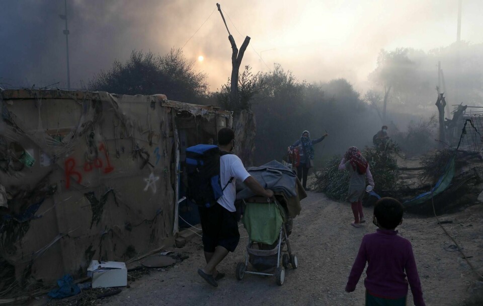 Flyktninger og migranter rømmer fra den brennende Moria-leiren på Lesvos.