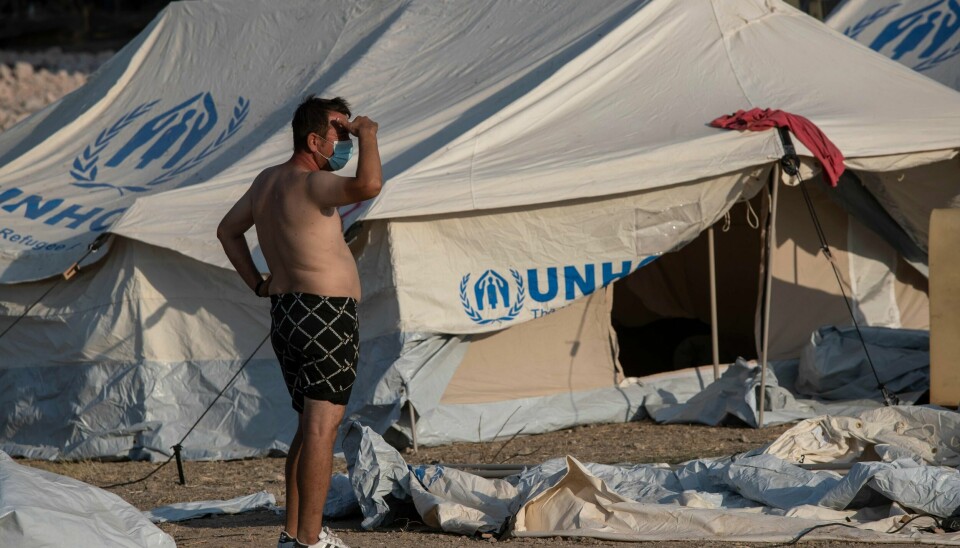 En asylsøker iført kortbukse og munnbind i den midlertidige teltleiren som er opprettet i nærheten av byen Mytilene på Lesvos. Foto: Petros Giannakouris / AP / NTB scanpix