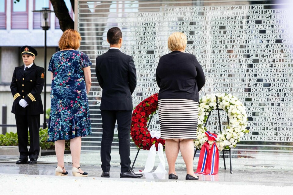 Støttegruppens leder Lisbeth Røyneland (nummer to fra venstre), AUF-leder Mani Hussaini og statsminister Erna Solberg la ned krans ved det midlertidige minnesmerket under minnemarkeringen i Regjeringskvartalet i Oslo søndag, sju år etter terrorangrepene 22. juli 2011. Foto: Audun Braastad / NTB scanpix