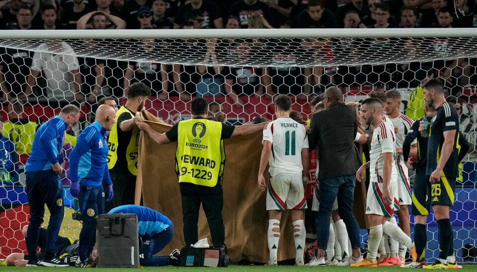 Funksjonærer og spillere holder et teppe foran Barnabás Varga som får behandling. Funksjonærer og spillere holder et teppe foran Barnabás Varga som får behandling. Foto: Matthias Schrader / AP / NTB