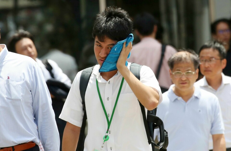En mann tørker svetten av ansiktet i Tokyos finansdistrikt. Over hundre mennesker døde i hetebølgen i Japan i sommer – kort tid etter at over to hundre omkom i flom.