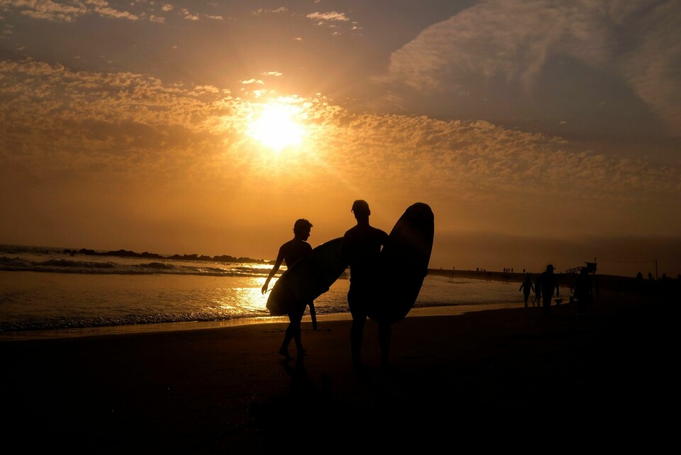 Surfere avkjøler seg som best de kan i heten på Venice Beach i Los Angeles. Surfere avkjøler seg som best de kan i heten på Venice Beach i Los Angeles. Foto: Ringo H.W. Chiu / AP / NTB