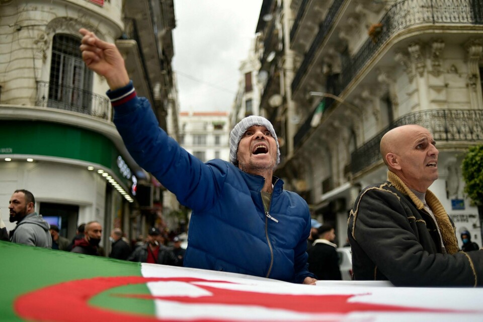 Algeriere marsjerer med nasjonalflagget under en demonstrasjon i hovedstaden Algeriere marsjerer med nasjonalflagget under en demonstrasjon i hovedstaden