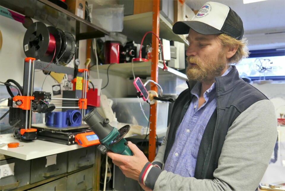 Ved hjelp av 3D-printeren i bakgrunnen, har Meier laget en miniprojektor. Printeren er nyttig når han skal lage verktøy han trenger, men som kanskje ikke finnes i butikkene. Hans Gerhard Meier og en fremviser, bygget av blant annet 3D-printede deler