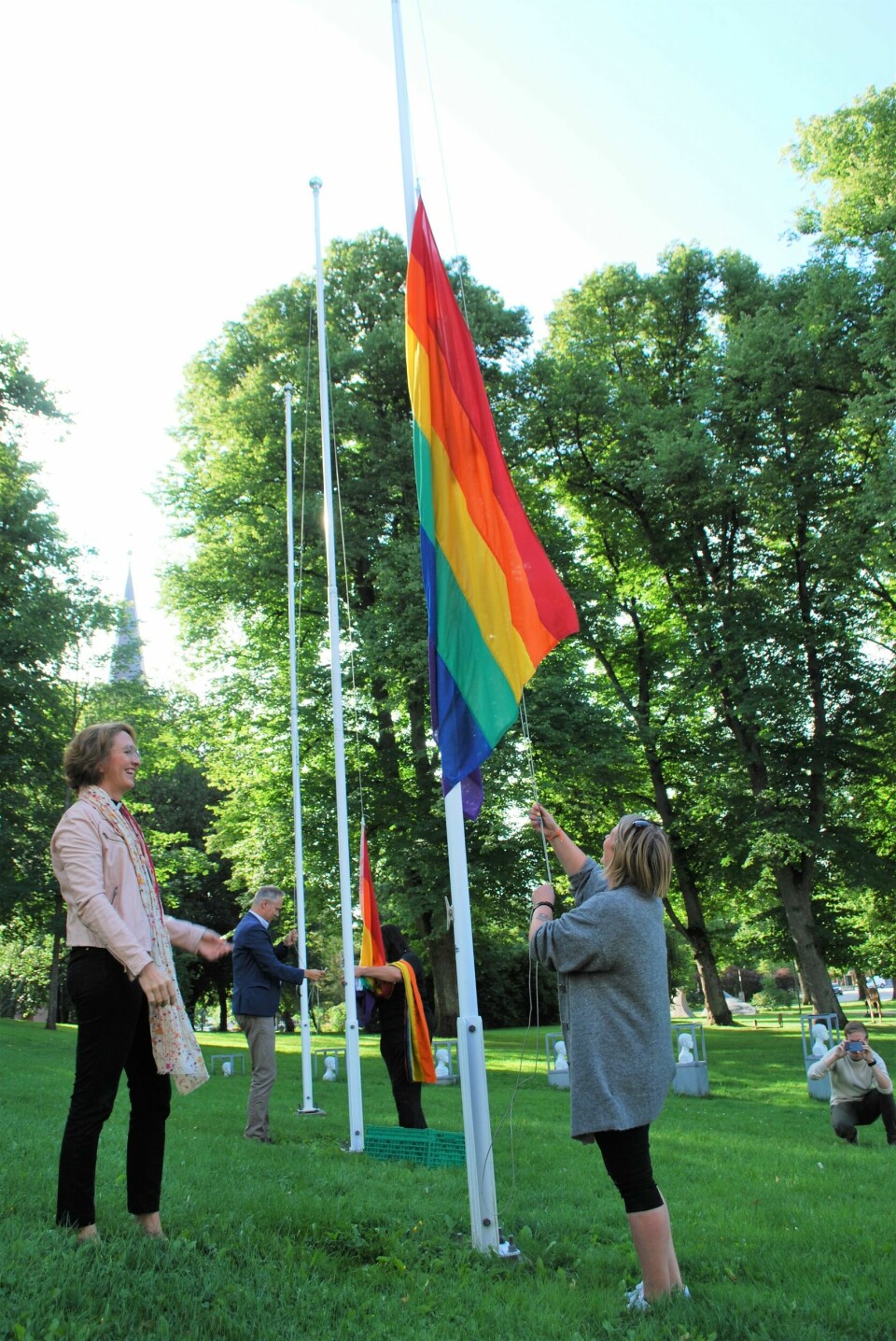 Smilene satt stadig løsere etter hvert som flaggene fant veien mot toppen. Domprost i Fredrikstad, Kari Mangrud Alvsvåg og styremedlem Hege Hansen i Fredrikstad Pride heiser regnbueflagget utenfor Fredrikstad rådhus. I bakgrunnen ordfører Jon-Ivar Nygård.