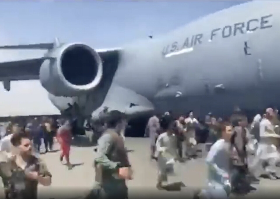 Bildene av mennesker som klamrer seg til fly i bevegelse på flyplassen i Kabul vekket sterke følelser verden over. Desperate folk løp ved siden av et transportfly av typen C-17 fra det amerikanske forsvaret idet flyet beveget seg mandag. Foto: UGC via AP / NTB