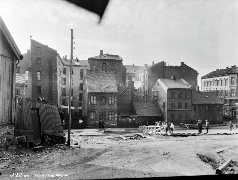 Den gamle bebyggelsen i Pipervika fotografert 28. august 1931, bare få dager før Rådhusets grunnsteinsnedleggelse. Forberedelsen er i gang. Den gamle bebyggelsen i Pipervika fotografert 28. august 1931, bare få dager før Rådhusets grunnsteinsnedleggelse. Forberedelsen er i gang.