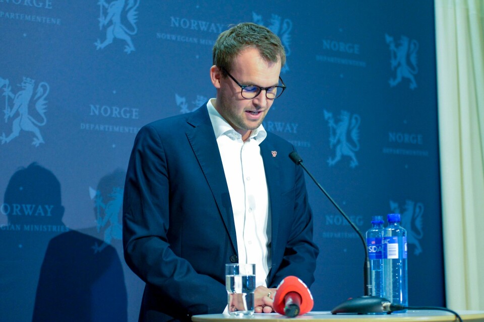 Kjell Ingolf Ropstad trakk seg som partileder i KrF og som statsråd på en pressekonferanse lørdag ettermiddag etter Aftenpostens sak om at han hadde tatt aktive grep for å unngå skatt på statsrådsboligen han benyttet. Bildet er Kjell Ingolf Ropstad. Han står i dress og ser ned på papirer som ligger på en talerstol. Han står foran en blå vegg. Foto: Annika Byrde / NTB