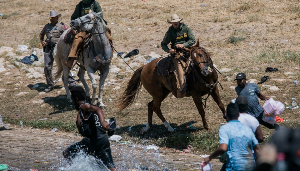 Ridende betjenter fra grensepolitiet forsøker å hindre migranter i å krysse elva Rio Grande fra Ciudad Acuña i Mexico til Del Rio i Texas. Ridende betjenter fra grensepolitiet forsøker å hindre migranter i å krysse elva Rio Grande fra Ciudad Acuña i Mexico til Del Rio i Texas. Foto: Felix Marquez / AP / NTB