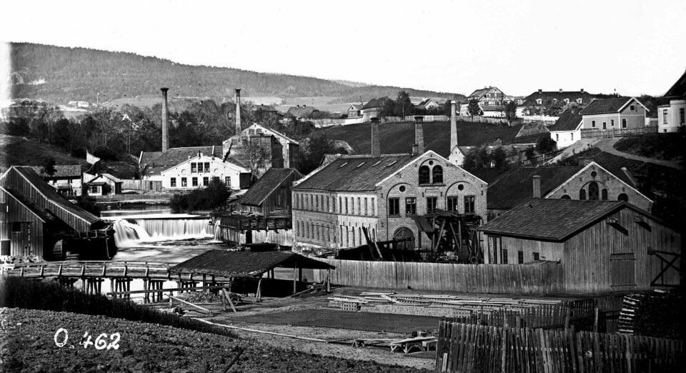 Myrens verksted cirka 1863–1883. Den eldste verkstedsbygningen ble flytta hit fra Øvre Foss og fikk etter hvert selskap av blant annet kjelebygninger, plate-, maskin- og monteringsverksteder. Myrens verksted cirka 1863–1883. Den eldste verkstedsbygningen ble flytta hit fra Øvre Foss og fikk etter hvert selskap av blant annet kjelebygninger, plate-, maskin- og monteringsverksteder.