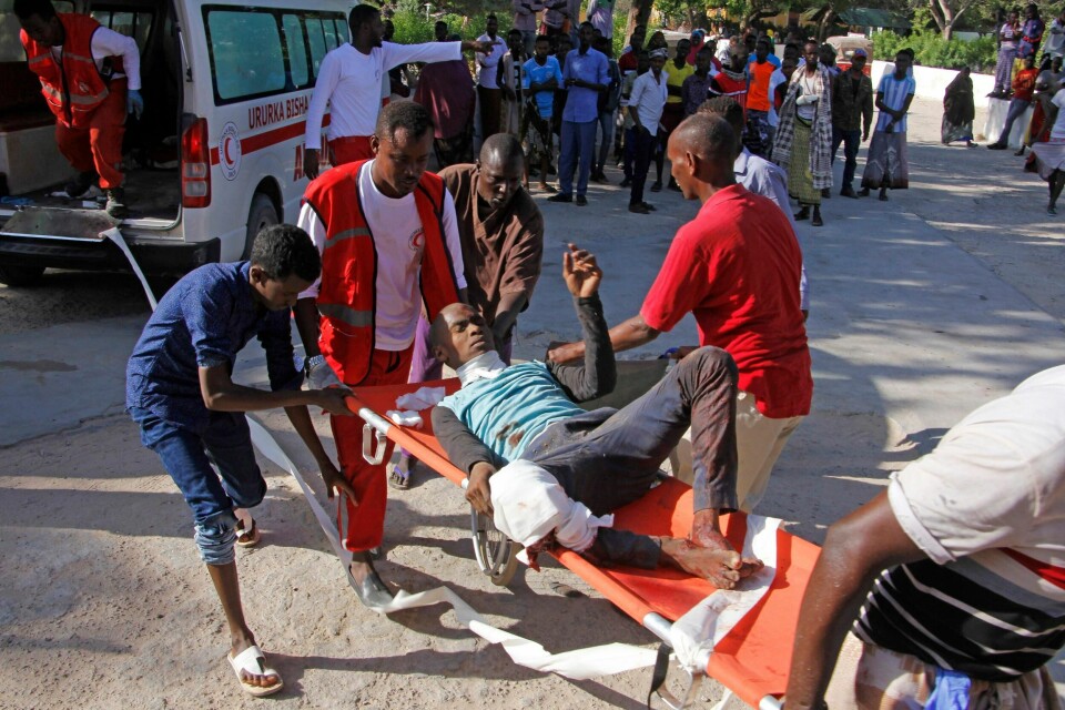 Helsepersonell frakter med seg en såret person etter lørdagens bilbombe i Mogadishu.