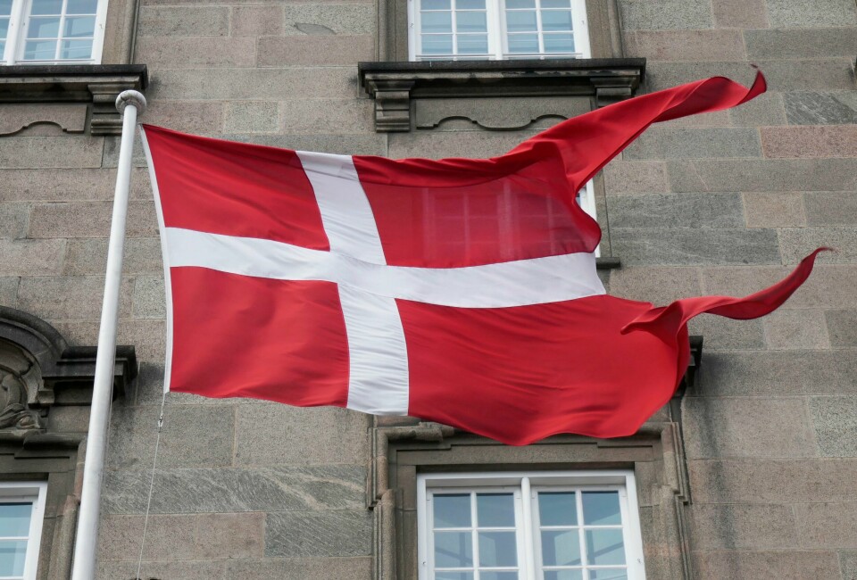 Det danske flagget Dannebrog vaier i vinden utenfor Christiansborg, det danske Folketinget, i den danske hovedstaden København. Danskene velger representanter til Folketinget 1. november. Foto: Erik Johansen / NTB