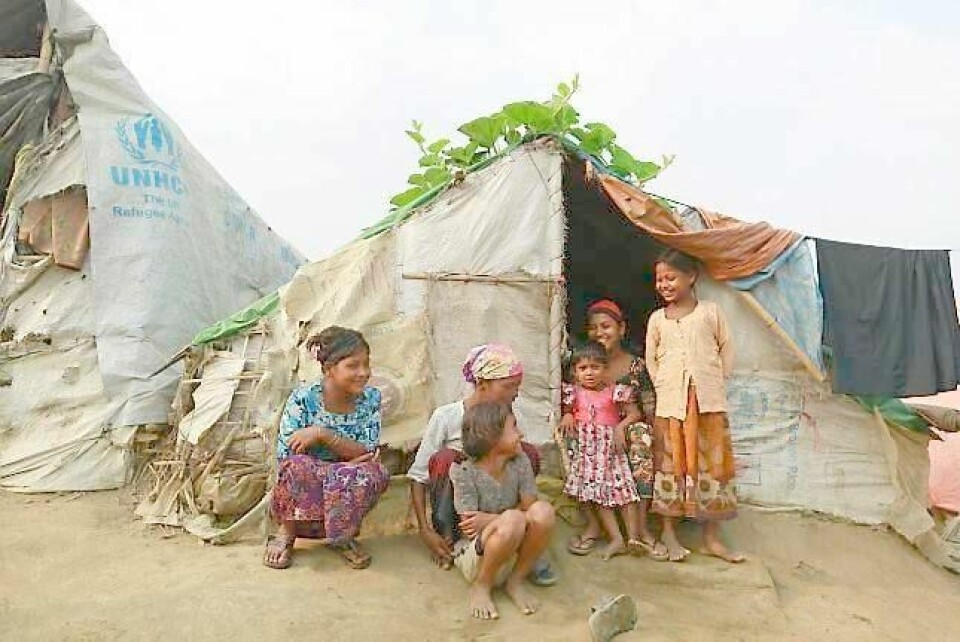 En familie sitter foran sitt midlertidige husly i en flyktningleir i Myanmar. Anders Anundsens fylkeslag vil at Norge skal gi alle flyktninger IKEA-hytter. FOTO: SOE ZEYA TUN/NTB SCANPIX