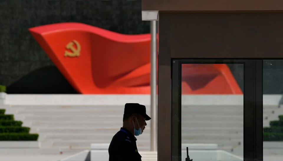 Illustrasjonsfoto. En sikkerhetsvakt ved en skulptur av flagget til det kinesiske kommunistpartiet i Beijing. Arkivfoto: Ng Han Guan / AP / NTB