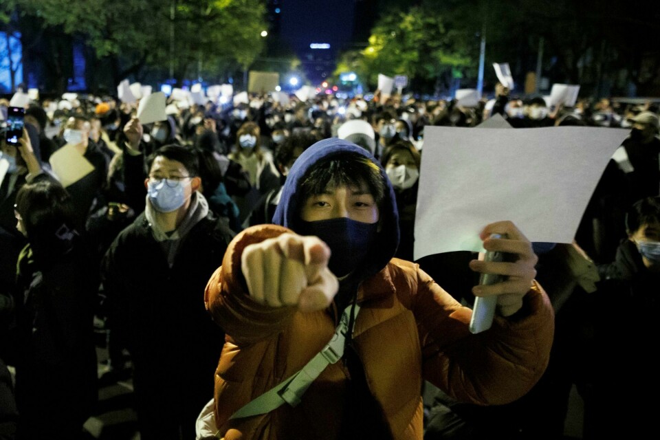Innbyggere holder opp blanke ark i protest mot koronarestriksjoner i Beijing søndag 27. november. Innbyggere holder opp blanke ark i protest mot koronarestriksjoner i Beijing søndag 27. november.