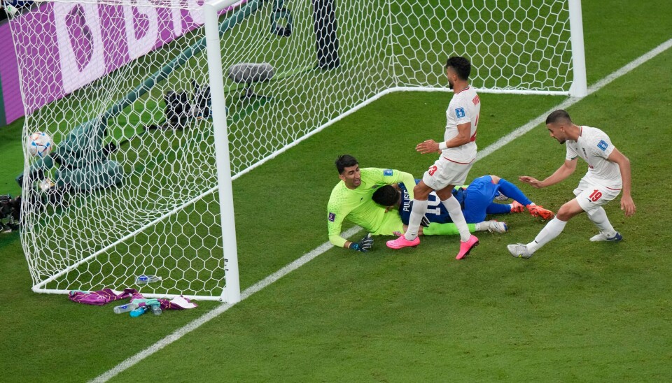 Christian Pulisic fikk et ublidt møte med den iranske keeperen Alireza Beiranvand like etter han satte inn 1-0 Christian Pulisic fikk et ublidt møte med den iranske keeperen Alireza Beiranvand like etter han satte inn 1-0. Foto: Luca Bruno / AP / NTB