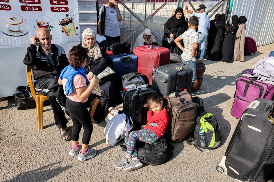 Folk venter ved Rafah-overgangen i Gazastripen for å komme seg til Egypt. People wait at the Rafah border crossing with Egypt in the southern Gaza Strip on November 1, 2023. Egypt is preparing to treat wounded Palestinians from the bombarded Gaza Strip starting November 1, with the opening of a border crossing to people after weeks of war, medical and security sources said. The border authority in the Hamas-ruled Gaza Strip said that Egypt had agreed to let in 81 of the most badly wounded through Rafah, the only crossing not controlled by Israel. (Photo by Mohammed ABED / AFP)