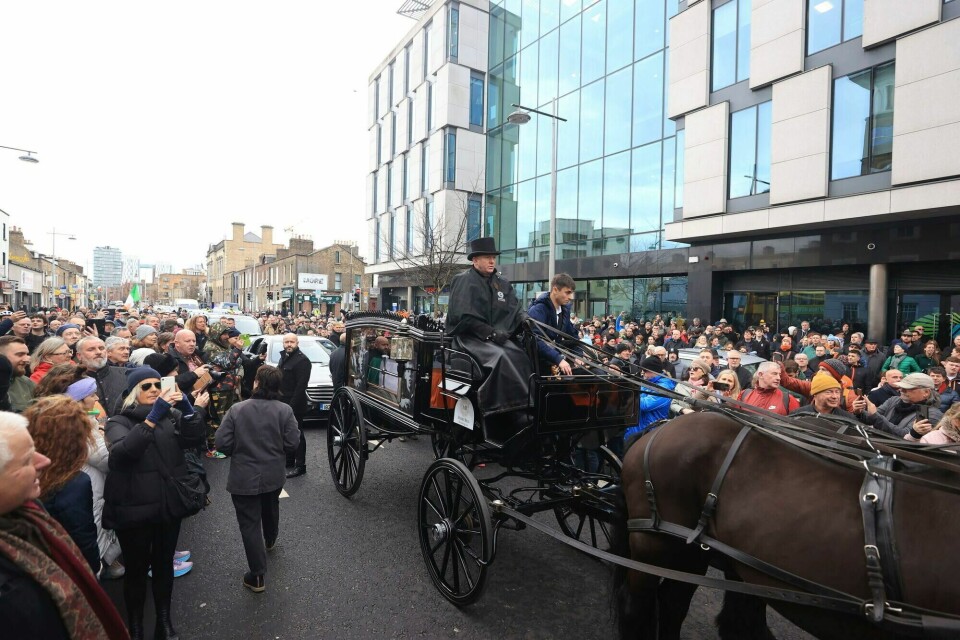 Shane MacGowans kiste ble kjørt gjennom gatene i Dublin fredag. En stor folkemengde hadde møtt opp for å ta farvel. Shane MacGowans kiste ble kjørt gjennom gatene i Dublin fredag. En stor folkemengde hadde møtt opp for å ta farvel.