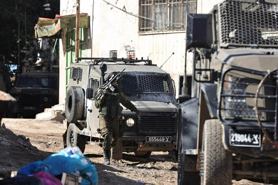 En israelsk soldat og militære kjøretøyer i Jenin flyktningleir onsdag. An Israeli soldier patrols in the Jenin refugee camp, in the occupied West Bank on November 29, 2023, during an ongoing military operation in the camp. (Photo by Zain JAAFAR / AFP)