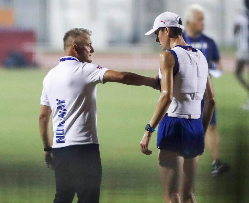 Jakob Ingebrigtsen med kjølevest (t.h.) og Gjert Ingebrigtsen på treningsbanen etter semifinalene på 1500 meter i Doha-VM fredag kveld. Foto: Lise Åserud / NTB scanpix.