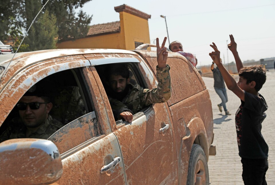 Tusenvis av syriske militssoldater, som støttes av Tyrkia, deltar i den tyrkiske militæroffensiven mot den kurdiske YPG-militsen nord i Syria. Members of Turkey-backed Syrian National Army (former FSA) flash the V-sign as they drive back to Turkey after they went in for some time on inspection according to the Turkish police entourage in the same area at the border between Turkey and Syria, in Akcakale, Sanliurfa province, southeastern Turkey, Wednesday, Oct. 9, 2019. Turkish President Recep Tayyip Erdogan has long threatened to send troops into northeastern Syria to clear the border region of Syrian Kurdish fighters whom Turkey considers a serious security threat. (AP Photo/Lefteris Pitarakis)