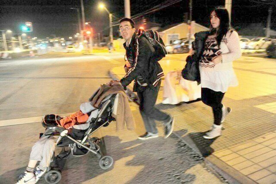 En chilensk familie rømmer kystområdet etter at et kraftig jordskjelv utløste tsunamivarsler. FOTO: JOSE LUIS SAAVEDRA/REUTERS/NTB SCANPIX