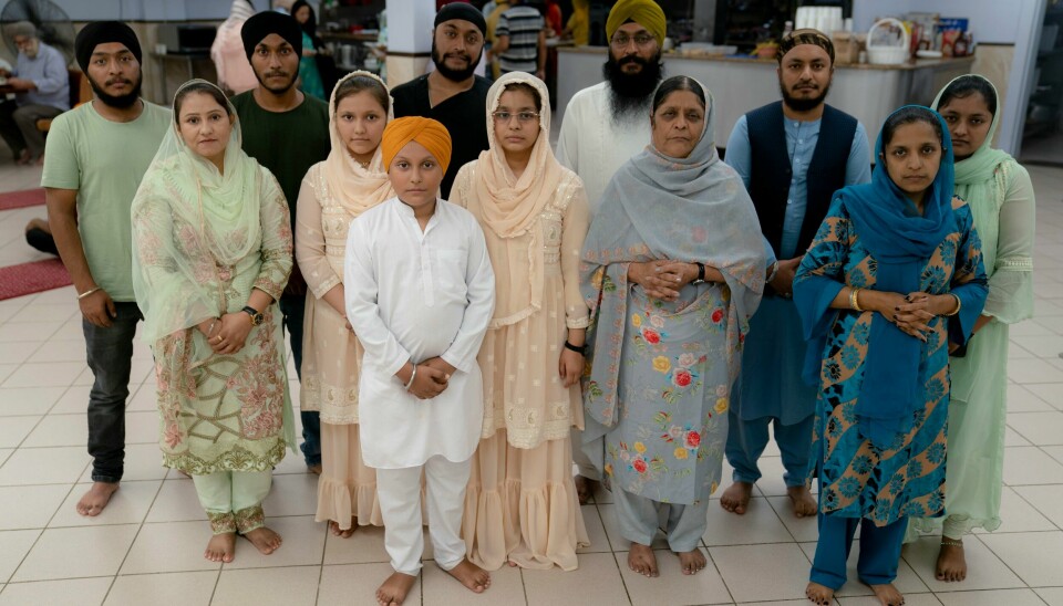 Amandeep Singh, 12, i hvitt, står sammen med familien sin i fellesrommet etter å ha deltatt på en bønnestund for sikher på Long Island. Den afghanske sikh-familien på 13 personer har flyktet til USA fra hjemlandet Afghanistan på grunn av forfølgelsen der. Amandeep Singh, 12, i hvitt, står sammen med familien sin i fellesrommet etter å ha deltatt på en bønnestund for sikher på Long Island. Den afghanske sikh-familien på 13 personer har flyktet til USA fra hjemlandet Afghanistan på grunn av forfølgelsen der. Foto: John Minchillo / AP / NTB