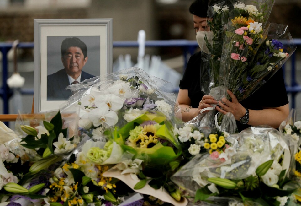 En sørgende legger ned blomster ved et bilde av Japans tidligere statsminister Shinzo Abe. Abes begravelse holdes tirsdag. En sørgende legger ned blomster ved et bilde av Japans tidligere statsminister Shinzo Abe. Abes begravelse holdes tirsdag.