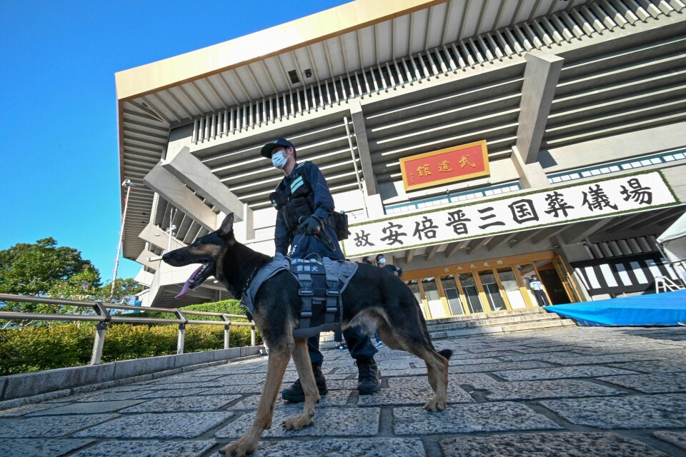 Det er varslet stort sikkerhetsoppbud før tirsdagens begravelse. En politimann og politihund patruljerer i Tokyo.