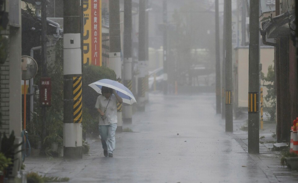 En person er ute i regnet i Tanabe i prefekturet Wakayama, der tyfonen Lan har nådd den japanske kysten. En person er ute i regnet i Tanabe i prefekturet Wakayama, der tyfonen Lan har nådd den japanske kysten. Foto: Kyodo News / AP / NTB