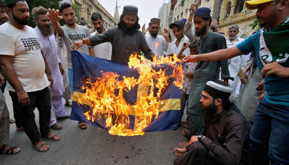 Koranbrenningene i Sverige og Danmark har skapt sterke reaksjoner i muslimske land. Her fra en demonstrasjon i Pakistans største by, Karachi, tidligere i sommer. FILE - Supporters of a radical Islamist party 'Tehreek-e-Labaik Pakistan' burn the representation of Swedish flag during a rally to denounce burning of Islam's holy book 'Quran', in Karachi, Pakistan, on July 7, 2023. A senior Swedish official said Monday Aug. 14, 2023 Swedes abroad and businesses linked to Sweden“should observe increased vigilance and caution,” following recent Quran burnings in the country and protests in the Muslim world. (AP Photo/Fareed Khan, File)