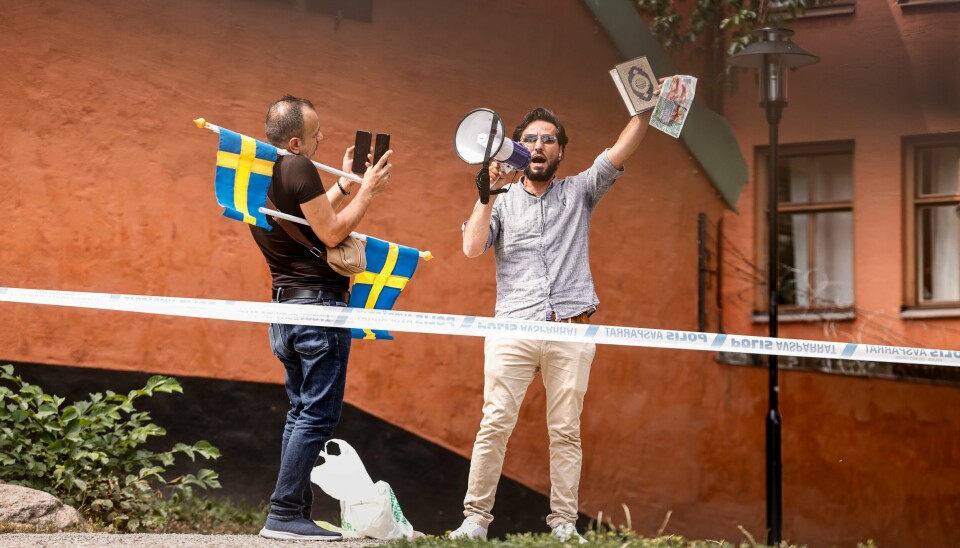 Salwan Momika (til høyre) er en av dem som har tent på koranen i ulike demonstrasjoner i Stockholm denne sommeren. Her ved en moské i Sveriges hovedstad. Stockholm, Sverige 20230628. Vi kommer att bränna Koranen. Vi kommer att säga: vakna Sverige, säger Salwan Momika, som ansökt om tillståndet.Polisen har kallat in förstärkning från hela landet för att hantera eventuella stökigheter kring arrangemanget med koranbränningen utanför Stockholms moské vid Medborgarplatsen på Södermalm i Stockholm.