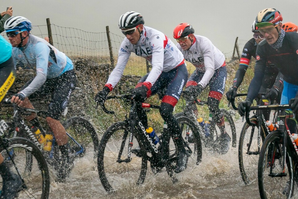 Sven Erik Bystrøm (t.v.) og Alexander Kristoff kjemper seg gjennom vannmassene under VM-fellesstarten søndag. Foto: Heiko Junge / NTB scanpix