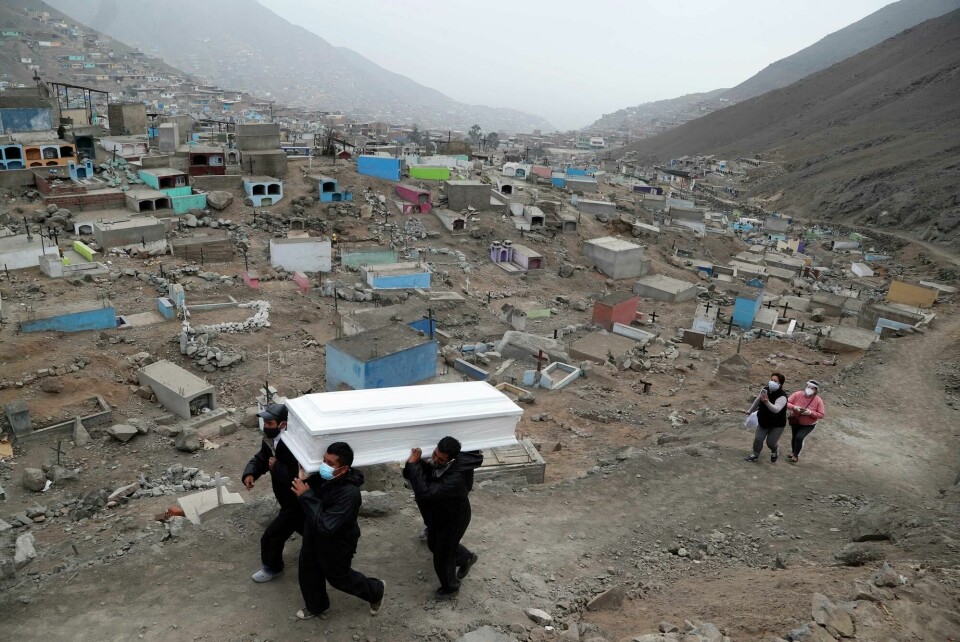 Peru har fortsatt nasjonal unntakstilstand. fra en begravelse i utkanten av hovedstaden Lima. Cemetery workers carry the coffin that contains the remains of Wilson Gil, who family members say died of COVID-19 related complications, to a burial site at the Martires 19 de Julio cemetery on the outskirts of Lima, Peru, Wednesday, Aug. 26, 2020. The South American country has the highest number of new coronavirus infections in Latin America after Brazil. (AP Photo/Martin Mejia)