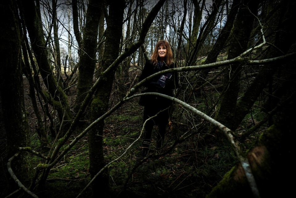 Sylvelin Vatle med sin ferske krim, her inne i en skog i nærheten av der hun selv bor på Ullandhaug. Foto: Roy Storvik. Sylvelin Vatle med sin ferske krim, her inne i en skog i nærheten av der hun selv bor på Ullandhaug. Foto: Roy Storvik.