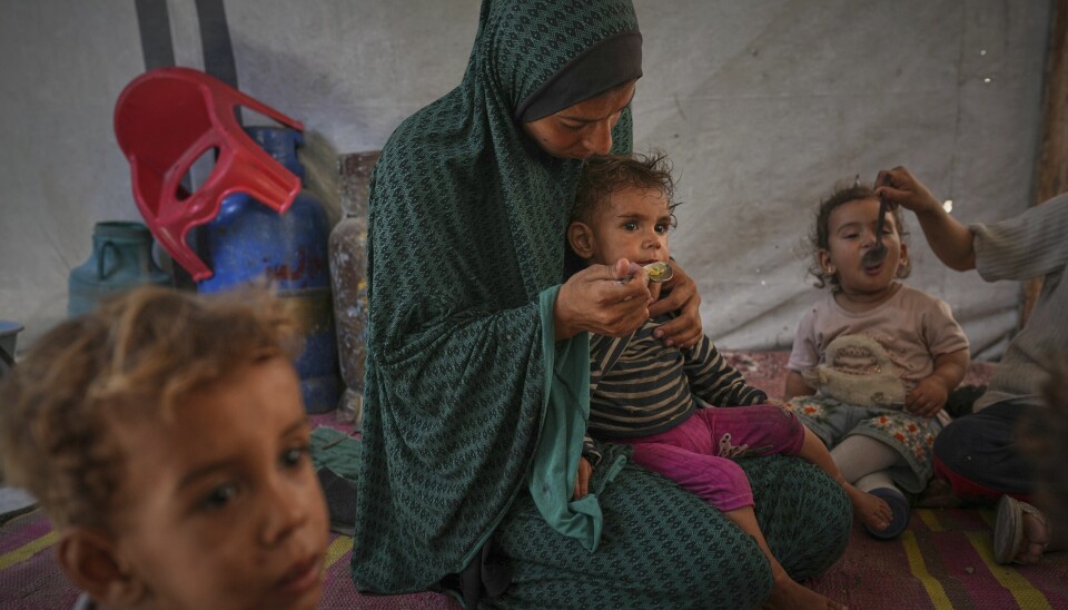 Barn får mat i et telt som huser en fordrevet familie i Gaza by i mai.