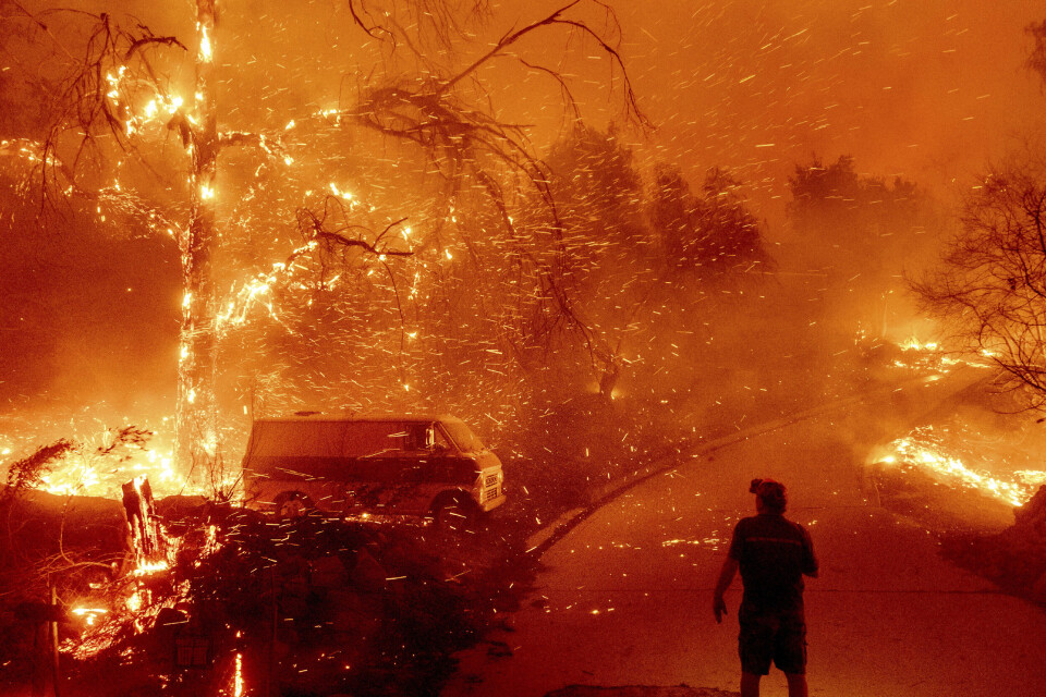 Mer ekstremvær, som flom, hetebølger ekstrem nedbør og skogbranner, er resultatet av klimaendringene. Her fra brannene som herjet California i USA i 2020. FILE - Bruce McDougal watches embers fly over his property as the Bond Fire burns through the Silverado community in Orange County, Calif., on Dec. 3, 2020. The United Nations on Monday, Feb. 28, 2022, released a new report on climate change. (AP Photo/Noah Berger, File)