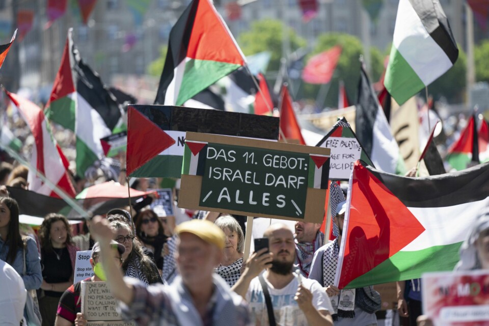Pro-palestinske demonstranter under åpningsseremonien av ESC-finale nummer 69 11. mai 2025, i Basel, Sveits.(Peter Schneider/AP) Propalestinske demonstranter holder opp en plakat der det står «Det 11. bud: Israel får gjøre som de vil». Foto: Peter Schneider / Keystone via AP / NTB