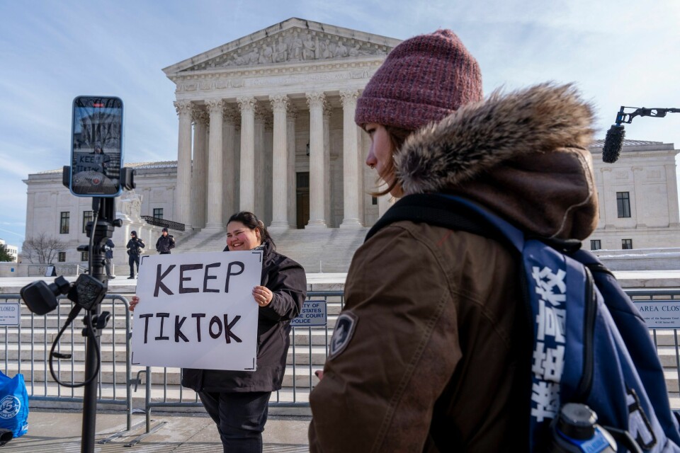 Mange amerikanere ønsker å beholde TikTok.(Jacquelyn Martin/AP) En demonstrant står foran USAs høyesterett med et skilt der hun oppfordrer dommerne til å stanse Tiktok-forbudet. En løsning på floken som ifølge Bloomberg er blitt diskutert i Kinas regjering, er å selge den amerikanske delen av virksomheten til Elon Musk. Foto: Jacquelyn Martin / AP / NTB
