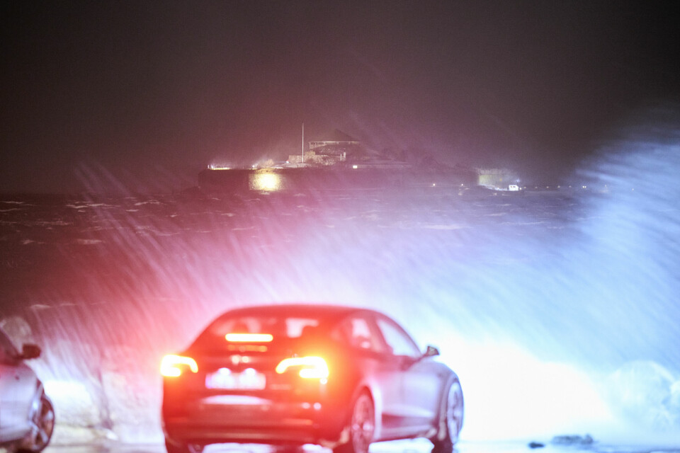 Det blåser heftig langs kysten, kombinert med mye nedbør og temperaturer som gir dårlig sikt og glatte veier. Det var full storm i Trondheim søndag kveld. Bildet er fra Munkholmen, sett fra Pirsenteret. Vannet fra Trondheimsfjorden piskes opp og inn på land over de skuelystne. Foto: Ole Martin Wold / NTB