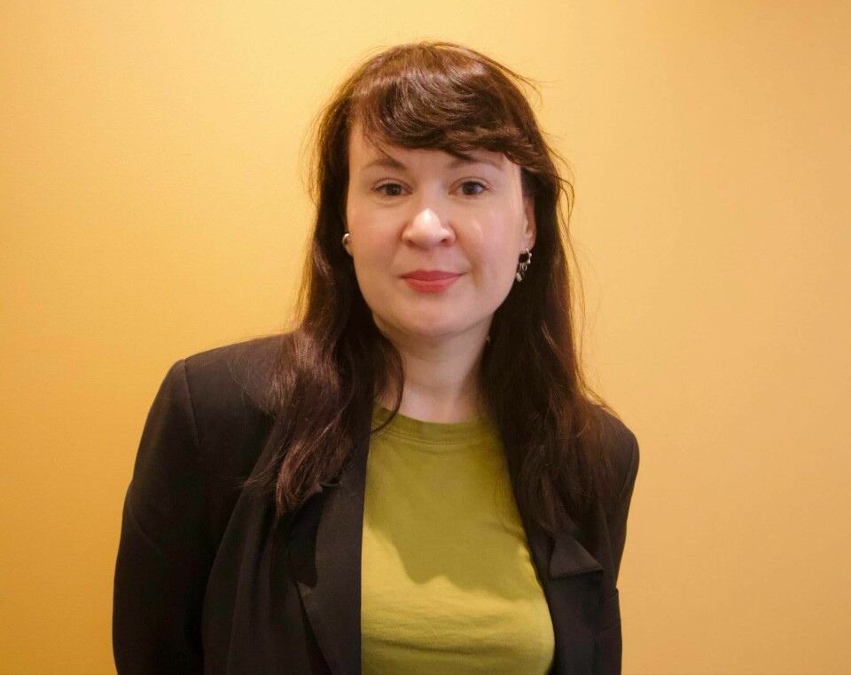 Hilde Sofie Pettersen er kommunikasjonssjef i CARE Norge.(Gabriella Løkke) Kvinne med svart hår og blazer står foran en oransje vegg og ser inn i kameraet.