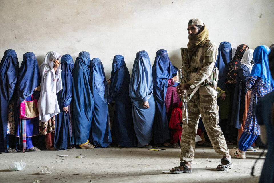 Årets kanskje mest dramatiske eksempel på tap av rettigheter for kvinner fant sted i Afghanistan. Der ble kvinners stemmer forbudt i offentligheten, skriver Kaj-Martin Georgsen. Bildet viser kvinner i kø for matrasjoner i Kabul, voktet av en væpnet Taliban-soldat. Kvinner i kø for matrasjoner i Kabul, voktet av en væpnet Taliban-soldat. (Afghanistan, kvinner, likestilling, Taliban)