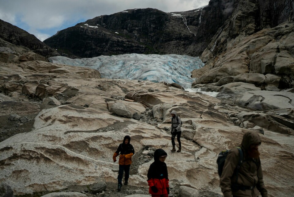 Isbreene i Skandinavia og på Svalbard hadde i fjor det største massetapet av alle verdens isbreregioner. Bildet av turister ved Nigardsbreen i Jostedalen i Sogn ble tatt i 2022. Nigardsbreen er en utløper fra Jostedalsbreen, den største isbreen på det europeiske fastlandet.(Bram Janssen/AP) Turister på Nigardsbreen, som har blitt nesten 3 kilometer kortere de siste hundre årene. Foto: Bram Janssen / AP / NTB