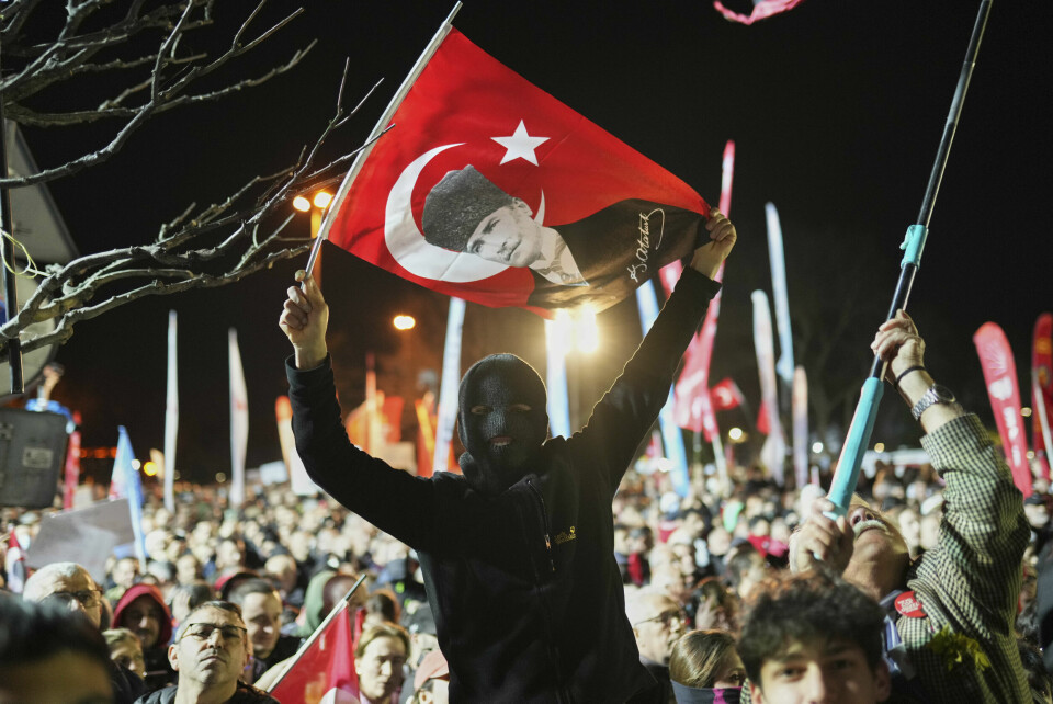 En maskert demonstranter holder opp et tyrkisk flagg med bilde av landsfaderen Mustafa Kemal Atatürk, som grunnla den moderne tyrkiske staten for drøyt 100 år siden. En maskert demonstranter holder opp et tyrkisk flagg med bilde av landsfaderen Mustafa Kemal Atatürk, som grunnla den moderne tyrkiske staten for drøyt 100 år siden. Foto: Francisco Seco / AP / NTB